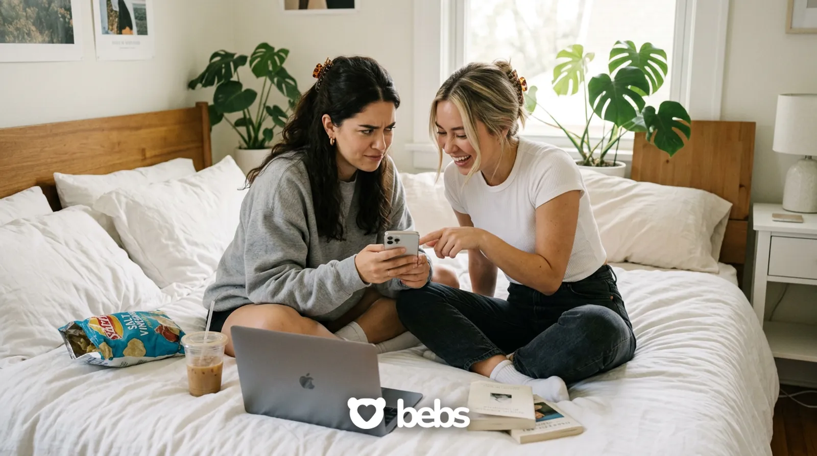 Two friends on a bed analyzing a text conversation on a phone, trying to figure out the signs someone likes you over text