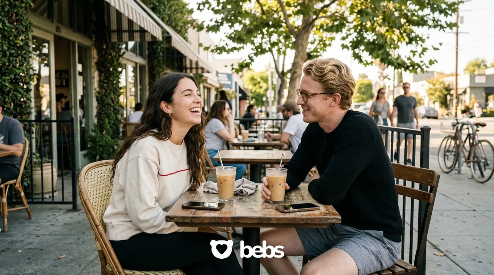Couple laughing on a real date at a sunny Los Angeles sidewalk cafe with phones on the table, how to avoid another situationship