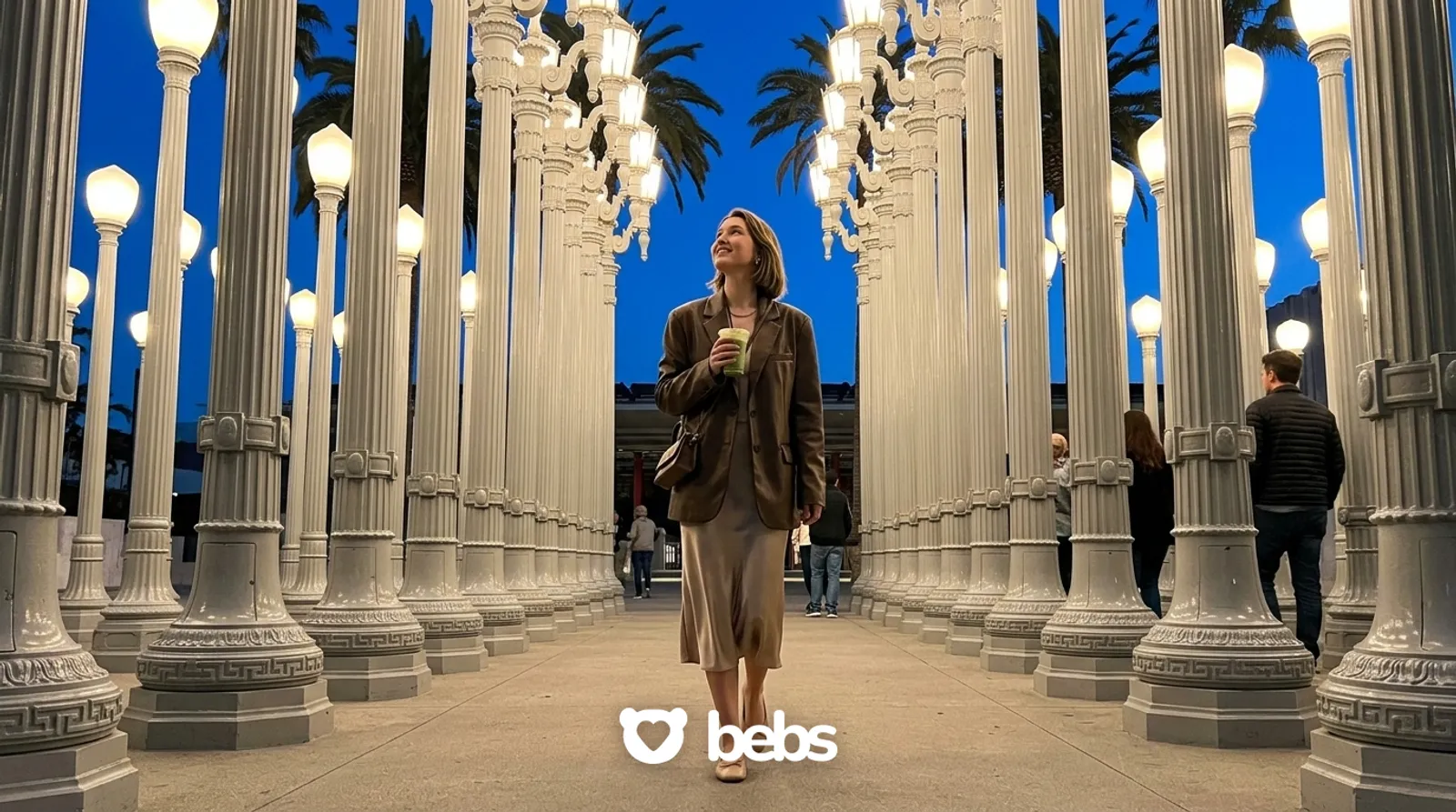 Young woman walking alone through the glowing lamps of Urban Light at LACMA at dusk, things to do alone in LA